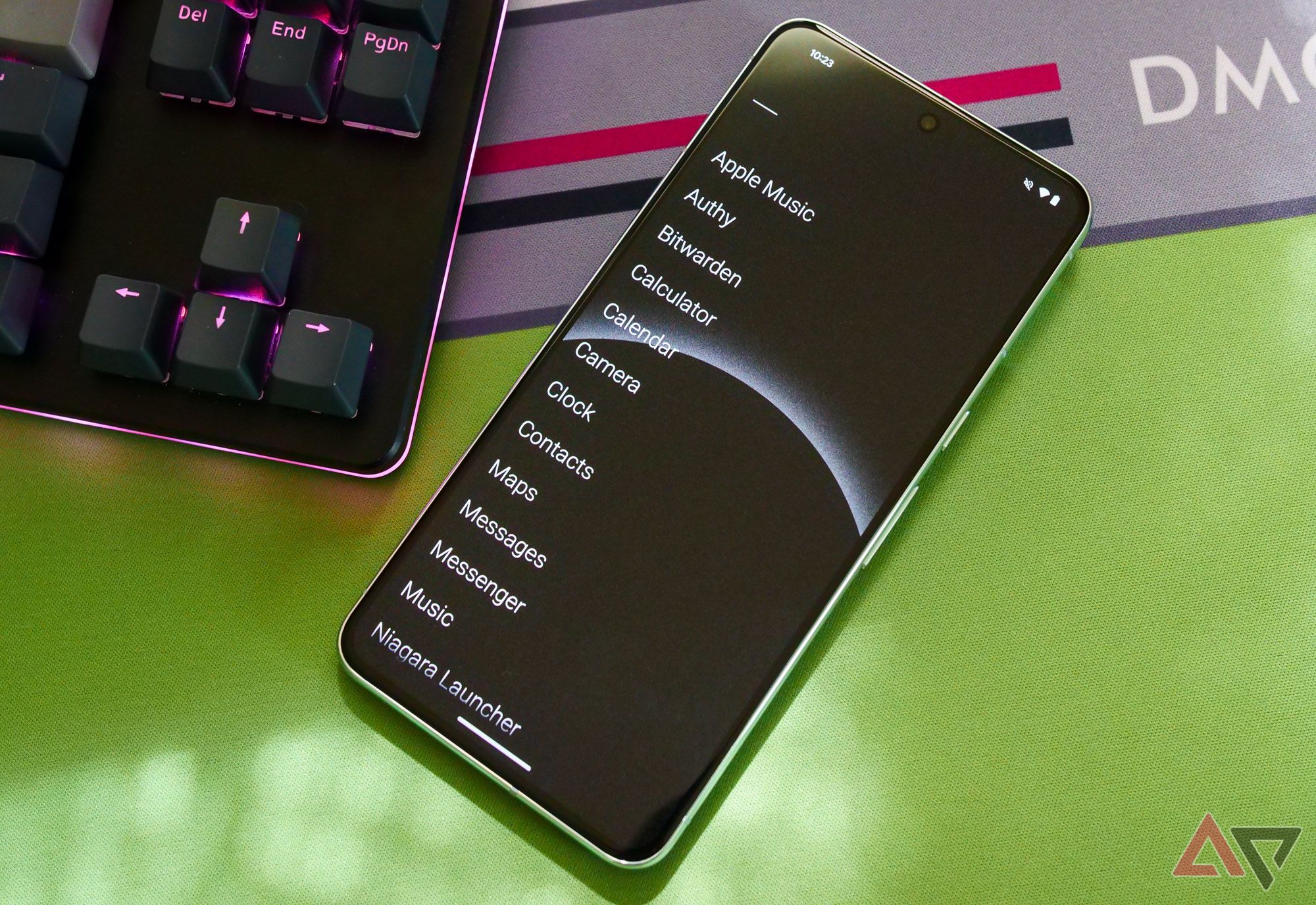 The Pixel 8 Pro is next to a keyboard with a list of apps on the screen.